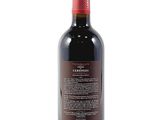 a bottle of red wine sitting on top of a white table