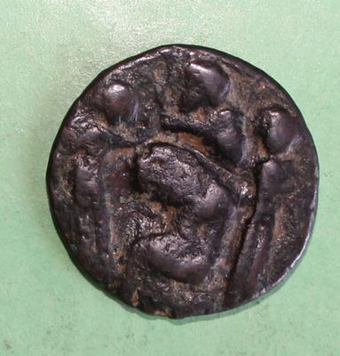 an old coin on a green surface with a picture of a man on it