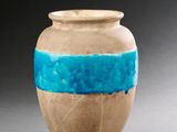 un vase marron orné d'une bande bleue
