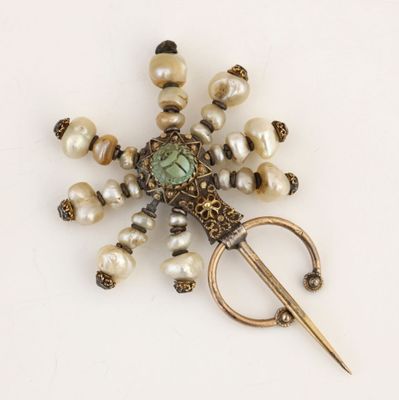 une photo d'une broche ornée de perles et d'une paire de ciseaux