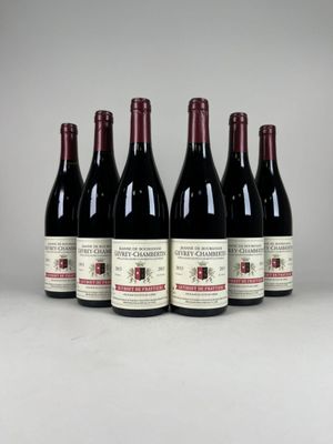 six bouteilles de vin sont alignées sur une table
