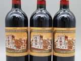 trois bouteilles de vin rouge posées côte à côte sur une table
