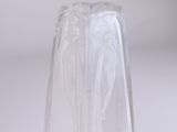 a clear glass vase with a white base on a table