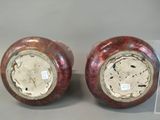 pair of red and silver vases sitting on top of a table