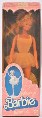 Poupée Barbie ballerine dans sa boîte, posée sur une surface blanche avec un fond rose