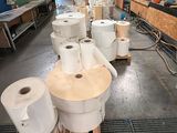 Plusieurs rouleaux de papier toilette sont alignés sur une palette dans un entrepôt