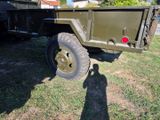a military truck with a flat bed parked in the grass