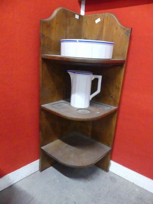 a corner shelf with a pitcher on top of it