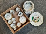 une boîte contenant des tasses à thé et leurs soucoupes, posée par terre
