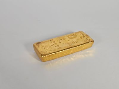 une barre d'or posée sur une surface blanche
