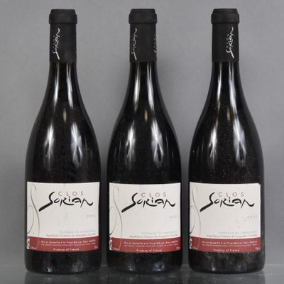 three bottles of wine are lined up on a table
