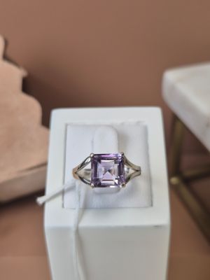 une bague en améthorate violette posée dans une boîte blanche sur une table