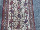 un tapis oriental posé à même le sol, sur lequel est allongé un chat