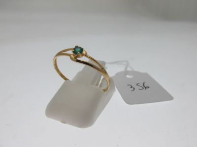 l'image d'une bague en or ornée d'une pierre verte