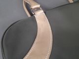 a close up of a black and gold bag on a table