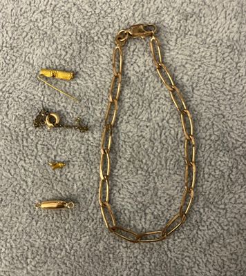 un gros plan sur un collier à chaîne en or et une paire de boucles d'oreilles