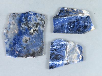 trois morceaux de marbre bleu et blanc posés sur une surface blanche