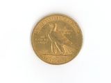 a gold coin with a bird on it on a white surface