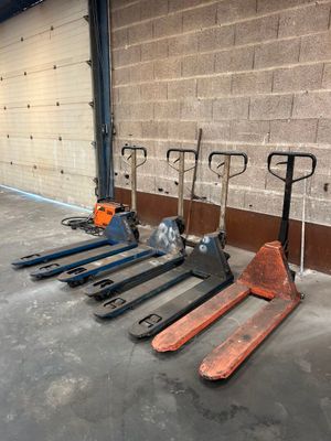 de nombreux types de chariots élévateurs alignés le long d'un mur