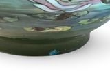 a colorful bowl with a flower in it on a white surface