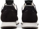 the black and white sneakers are lined up on a white surface