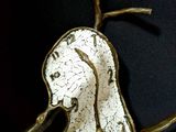 a sculpture of a bird on a branch with a clock on it ' s face