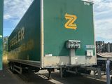 un semi-remorque vert garé sur un parking