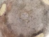 a silver plate with gold dots on it on a white surface