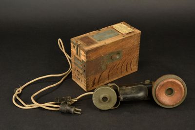 a wooden box and two old fashioned telephones on a black background