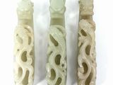 three jade carved vases sitting next to each other on a white surface