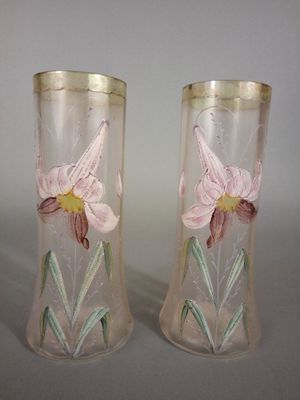 two vases with flowers painted on them sitting on a table