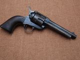 a gun that is laying on top of a brown surface