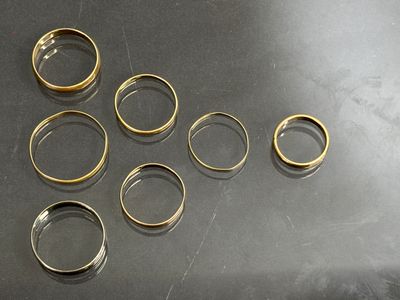 beaucoup de bagues en or posées sur une table
