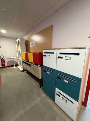 Plusieurs classeurs sont alignés dans une pièce, avec une borne d'incendie en arrière-plan.
