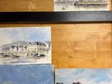 peintures sur un mur en bois représentant une plage et un bâtiment