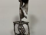 bronze statue of a woman holding a vase on a table