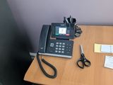 a desk with a telephone and a pair of scissors on it
