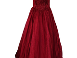 une robe de bal rouge suspendue à un cintre sur fond blanc