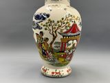 un vase avec un tableau posé sur une table