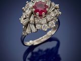 a close up of a diamond and ruby ring on a blue background