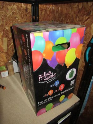 une boîte posée sur une chaise, avec des ballons