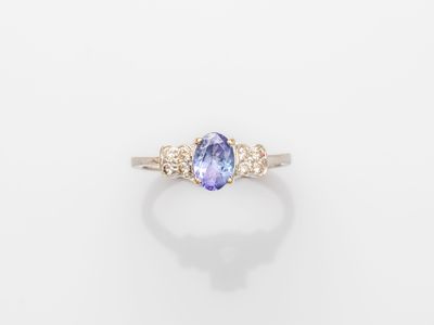 an oval tanzane and diamond ring on a white background