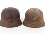 pair of old rusty helmets on white background
