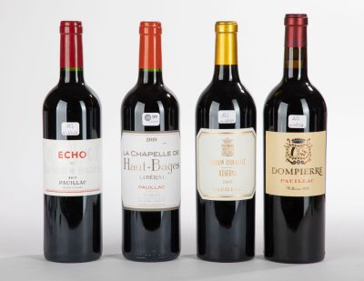 trois bouteilles de vin rouge sont alignées sur une surface blanche