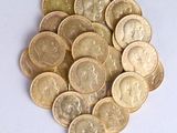 a pile of gold coins on a white surface