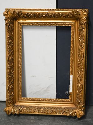 an ornate gold frame with a black background and a white wall