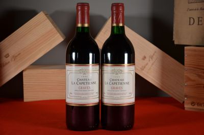 two bottles of wine sitting next to each other on a table