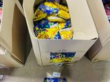 Plusieurs cartons de nourriture sont empilés par terre dans un magasin.