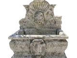 a stone sink with a lion head on it