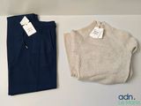 deux pantalons et un pull posés sur une table